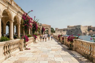 Vue grand angle des jardins Upper Barrakka à La Valette, Malte, avec les arcades en pierre calcaire et le Grand Port en arrière-plan